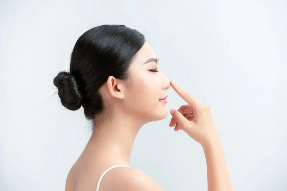 Side profile of a woman touching the bridge of her nose